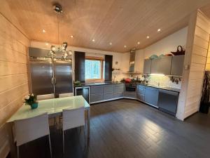 a large kitchen with a table and chairs in it at Villa Polly, Jaala, Luxury cottage with private sauna in Kouvola +56 photos