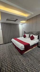 a hotel room with a large bed with red pillows at اصداء الراحة للشقق المخدومة 3 in Riyadh