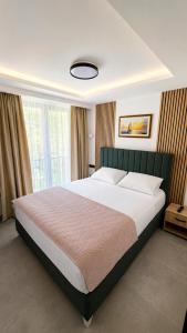 a bedroom with a large bed with a large window at Kamel Rooms & Apartments in Bijelo Polje