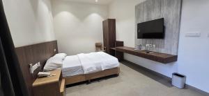 a bedroom with a bed and a flat screen tv at ANTARA STAY in Coimbatore