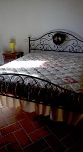 una camera da letto con letto con struttura nera di Casa Vacanze in Borgo a Monteverdi Marittimo