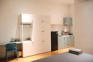 a kitchen with white cabinets and a black refrigerator at GIA Hotel & Serviced Apartment in Nhơn Trạch +12 photos