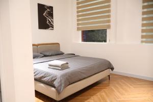 a bedroom with a bed in a white room at GIA Hotel & Serviced Apartment in Nhơn Trạch