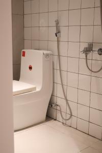 a white toilet in a bathroom with a shower at GIA Hotel & Serviced Apartment in Nhơn Trạch