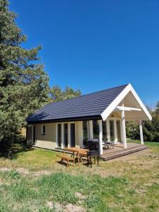 a house with a picnic table in front of it at Papės Perlas in Pape