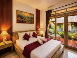 a bedroom with a large bed in a room at Purnama House Ubud in Ubud
