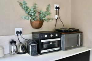 a kitchen counter with a stove and a microwave at Bushveld Venue in Mabula