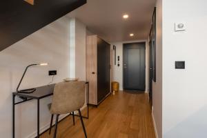 a room with a desk and a chair and a hallway at Old Town Loft in Tartu
