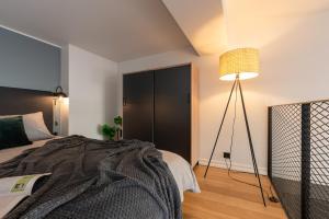 a bedroom with a bed and a floor lamp at Old Town Loft in Tartu
