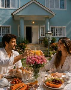 a man and woman sitting at a table with food at Pousada Jupter in Teresópolis