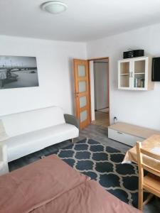 a living room with a white couch and a table at Bowal in Grzybowo