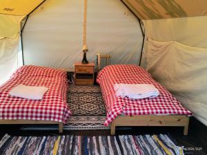two beds in a tent with a table at Moto Keja Bieszczady in Uherce Mineralne (7)