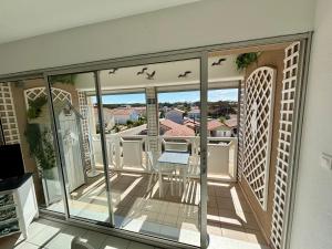 a balcony with glass doors and a table and birds at Le Surf in Mimizan-Plage +4 photos