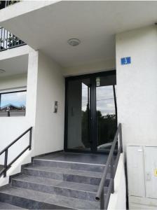 a staircase leading up to a building with glass doors at Blue Apartment Riverside in Podgorica