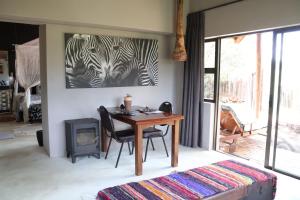 a room with a table and a picture of zebras at Bushveld Venue in Mabula