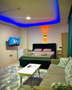a bedroom with a bed and a couch and a tv at Damla Apart Otel in Buca