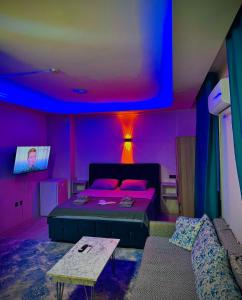 a room with a bed and a couch and a tv at Damla Apart Otel in Buca