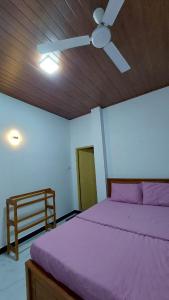 a bedroom with a purple bed and a ceiling fan at Summer Dream in Badulla +9 photos