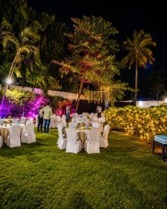 a group of tables and chairs in the grass at night at Pride Premier Nagpur in Nagpur