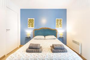 a blue bedroom with a bed with two pillows at La Longère du Salou in Landrévarzec
