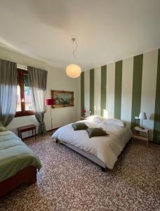 a bedroom with two beds and green and white stripes at Casa dell'OCA in Viganò +37 photos