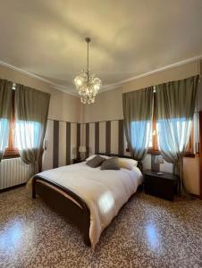 a bedroom with a large bed and a chandelier at Casa dell'OCA in Viganò