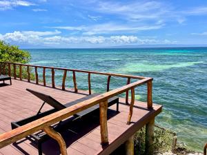 a wooden deck with a bench overlooking the ocean at Crossa Inn in Siquijor