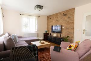 a living room with two couches and a brick wall at Anuskina kuca in Pakovrače