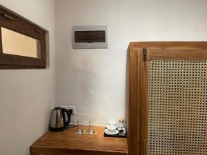 a room with a wooden cabinet and a coffee maker on a table at Villa Flamingo in Ahangama
