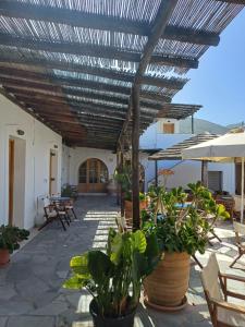a patio with awning and chairs and plants at Siroco's Rooms And Studios in Parikia