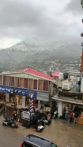 a view of a building with snow covered mountains in the background at Hotel Atithyam in Solan