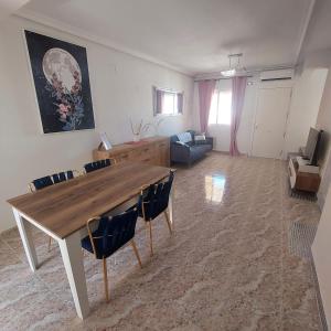 a living room with a wooden table and chairs at CASA LUTHI Costa Blanca in Orihuela Costa