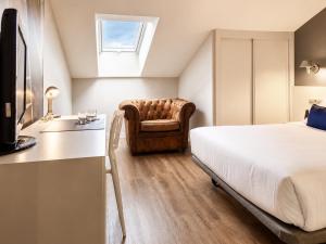 a bedroom with a bed and a chair at Hotel Andia in Orcoyen