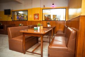 a dining room with a table and leather chairs at Tokyo Hotel in Kathmandu +18 photos