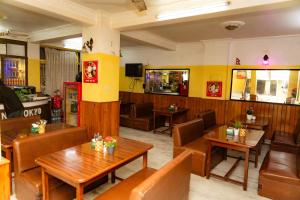 a restaurant with wooden tables and leather chairs at Tokyo Hotel in Kathmandu