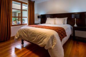 Un dormitorio con una cama grande y una ventana en Illa Hotel, en Cusco