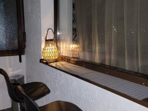 two lights sitting on a window ledge next to a chair at Apartament Benicarlo2 in Brad