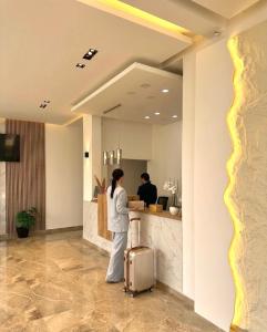 a woman standing in an office with a suitcase at SUPREME Luxury in Ulcinj