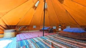 a tent with two beds and a rug in a room at Hà Giang Camping in Mèo Vạc