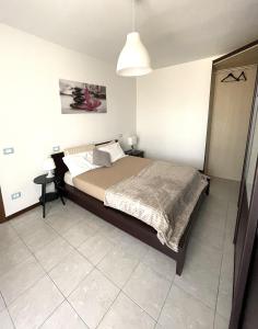 a bedroom with a large bed and a lamp at A casa di Any in Cascina