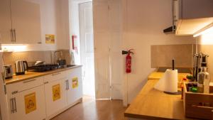 a kitchen with white cabinets and a counter top at Onefam Clerigos in Porto