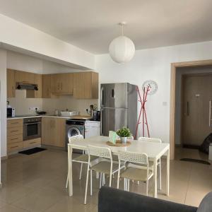 a kitchen with a white table and chairs in a room at Obv 2-303 in Pyla