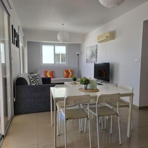 a kitchen and living room with a table and chairs at Obv 2-303 in Pyla