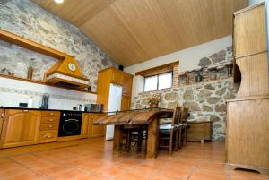 a kitchen with a table and a stone wall at Casa Del Palacio in Aguilafuente