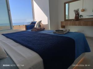 a bedroom with a blue bed with towels on it at Blue Aura Beach villa Larnaca in Perivolia