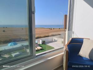 a window with a view of the beach and the ocean at Blue Aura Beach villa Larnaca in Perivolia