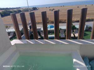 a swimming pool with a fence and a view of the beach at Blue Aura Beach villa Larnaca in Perivolia