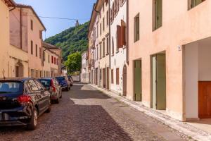 a cobblestone street with parked cars and buildings at Alle Porte in Vittorio Veneto