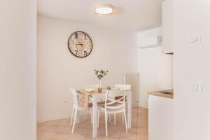 a dining room with a table and a clock on the wall at Alle Porte in Vittorio Veneto +9 photos