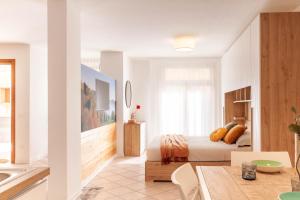 a white bedroom with a bed and a table at Alle Porte in Vittorio Veneto